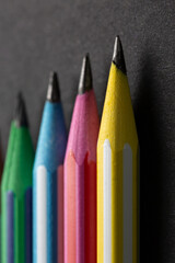 colored pencils in row on a black background
