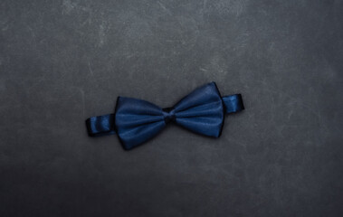 Bow tie on black background. Gentleman's accessories. Top view