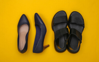Women's leather shoes with heels and sandals on a yellow background. Top view
