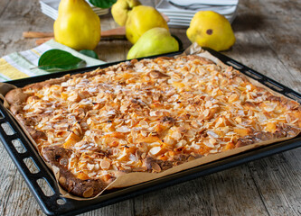 Butter almond cake with quinces on a baking tray