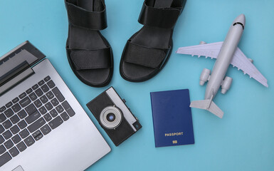 Laptop and travel accessories on a blue background. Top view. Flat lay