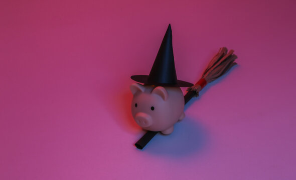 Piggy bank in a witch's hat on a broomstick. Red-blue gradient neon light. Halloween theme