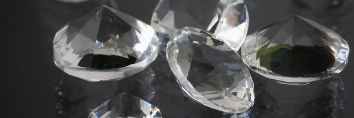 Precious expensive stones lie on black background. Sale of diamonds and polished diamonds creation...