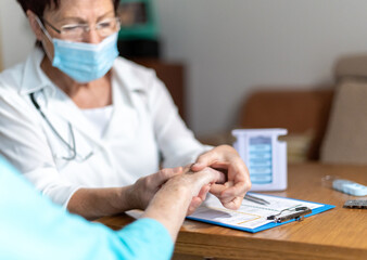 Ärztin untersucht Patientin an der Hand