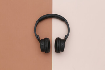 Wireless stereo headphones on brown beige background. Top view