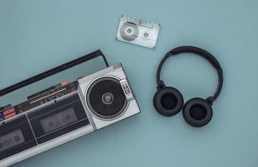 Boombox audio tape recorder, stereo headphones and audio cassette on a blue background. Retro 80s....