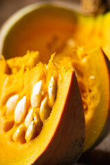 Freshly harvested pumpkin sliced on the kitchen table. Selective focus. Shallow depth of field.