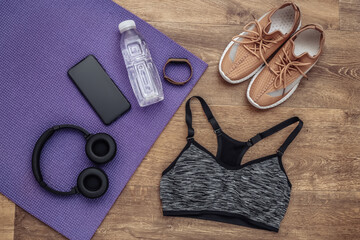 Flat lay composition of Sports equipment, clothes on a wooden floor. Fitness, sport and healthy lifestyle concept. Top view