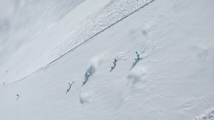FPV drone AERIAL: a group of professional skiers ride synchronously along the track in white and blue suits. four ski instructors demonstrate synchronized slalom. Drone for racing, action movies, 2k