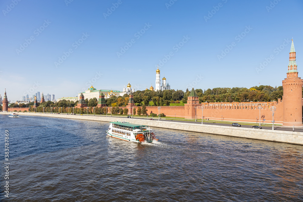 Wall mural view of Moskva river with excursion boat near Kremlin embankment from Bolshoy Moskvoretsky Bridge on sunny autumn day