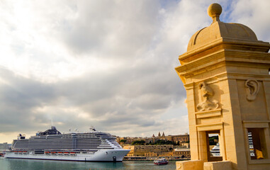 Mega modern MSC cruiseship or cruise ship liner in port of Valletta, Malta island with panoramic...