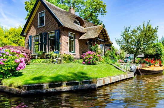 GIETHOORN, NETHERLANDS - JULY 17,2016: view of typical houses of Giethoorn on July 17, 2016 in Giethoorn,The Netherlands. The beautiful houses and gardening city is know as "Venice of the North".