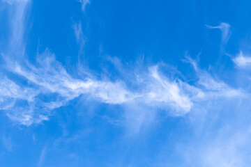 white cirrus cloud high in blue sky on sunny autumn day