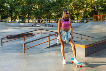 Image of young stylish woman skater with cruiser board on skate park
