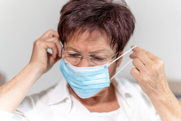 Ärztin setzt sich eine Maske auf