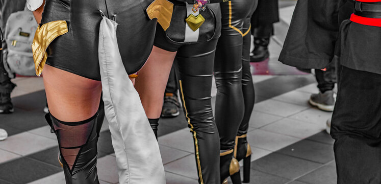 Close up shot of young girls and women dressed up for Halloween. Cosplayers, female models, leather outfit, naked legs. 