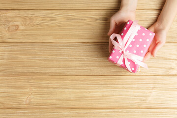gift box in the hands on a wooden background