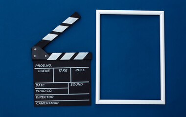 Fototapeta na wymiar Film clapper board with white frame for copy space on classic blue background. Cinema industry, entertainment. Top view