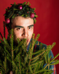 attractive man in a plaid shirt on a red background hair like a christmas tree christmas mood copyspace