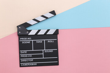 Fototapeta na wymiar Movie clapper board on colored pastel background. Cinema industry, entertainment. Top view