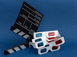 Movie clapper board with 3d glasses on classic blue background. Cinema industry, entertainment