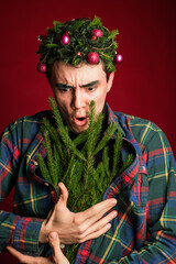 attractive man in a plaid shirt on a red background hair like a christmas tree christmas mood copyspace