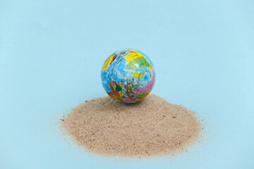 Summer beach travel vacation concept. Globe on an island with sand
