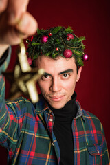 attractive man in a plaid shirt on a red background hair like a christmas tree christmas mood copyspace