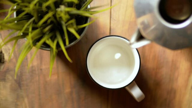 Pouring coffee in cup. Espresso coffee using moka coffee maker. 