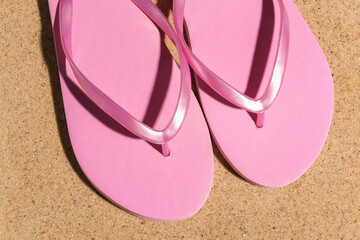 Summer beach travel vacation concept. Flip flops on sand at bright sunny day. Top view
