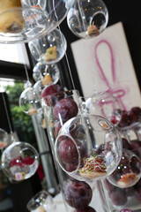 Canapés served in hanging glass domes at an event.