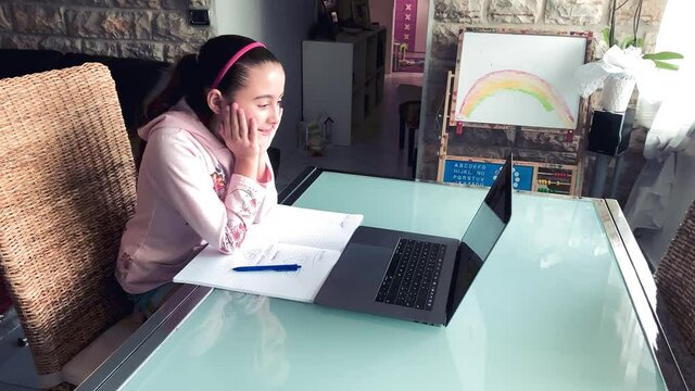 Distance Learning concept. Schoolgirl following course on the laptop with teacher explaining lesson