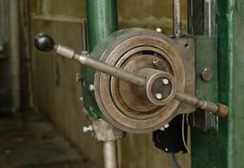 Drilling machine flywheel. Old drilling machine in the workshop.