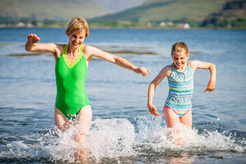 Mother and Daughter Running in the Sea