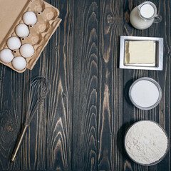 top view of flour, eegs, milk and sugar on desk at kitchen