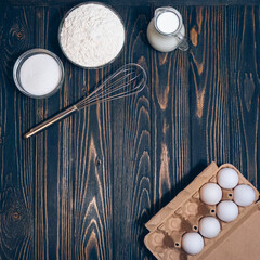 Baking cake ingredients: flour, sugar, eggs on wooden desk, flat lay