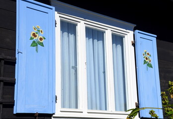 Hellblaue Fensterläden an einem historischen Holzhaus im Spreewald