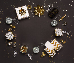 Christmas composition. Gold and silver decorations, mirror disco balls, gifts on  dark black background.