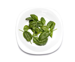 Fresh spinach. Green vegetables leaves on a plate, healthy food, vegetarian diet concept.