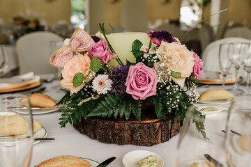 wedding table setting with flowers. Centerpiece with natural flowers in pink tones for an elegant rustic style event