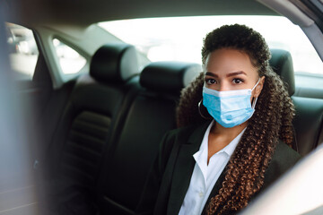 Young waiter in  protective face mask and gloves while bringing food to a customer in cafe during coronavirus epidemic. Covid- 2019.
