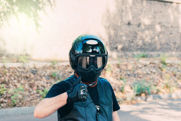 biker with black helmet leather vest and thumb up