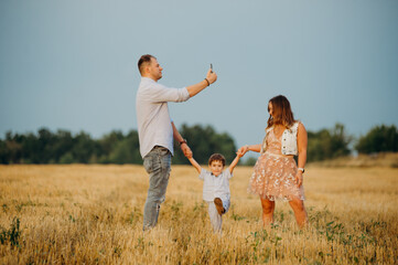 Happy family in the field evening light of a sun.