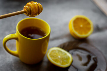 black tea with honey, lemon on a gray background
