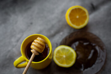 black tea with honey, lemon on a gray background