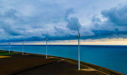 Wind turbines by the sea, generating clean energy on a stormy day.
