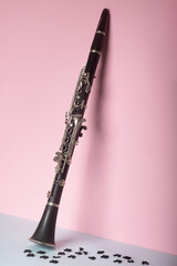 clarinet with wood musical notes on blue and pink background