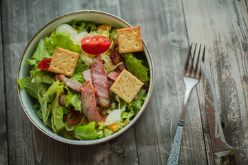 Fresh vegetable salad with slices of bacon. Caesar salad cooked at home