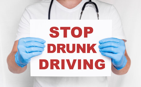 Closeup doctor hands holding white card sign with Stop Drunk Driving text message isolated on white background. Healthcare concept. Medicine doctor hand working