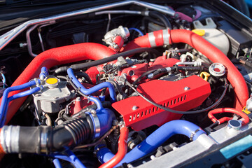 Sports motor with red intake elements close up on a sports car